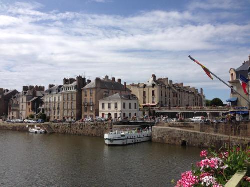 a boat in a river in a city with buildings at Le Duplex des Eclusiers in Redon