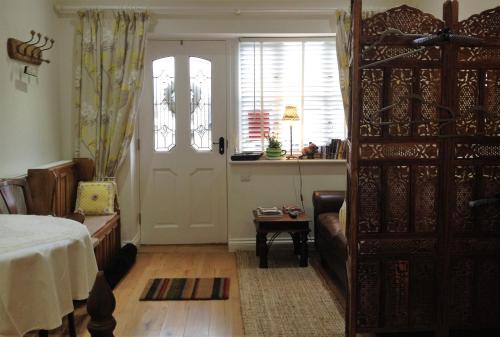 een slaapkamer met een bed, een deur en een tafel bij Snowdonia Snug - Studio Style Accommodation in Dolgellau