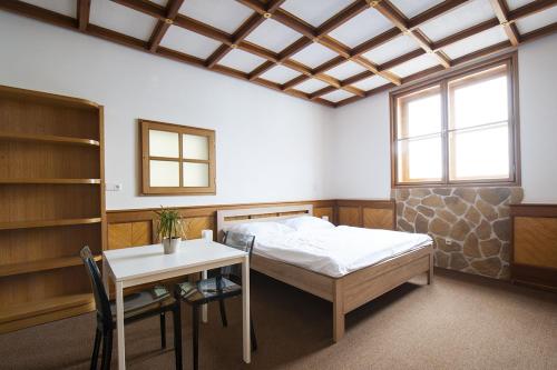 a bedroom with a bed and a desk and a table at Penzion Na Náměstí in Mikulov