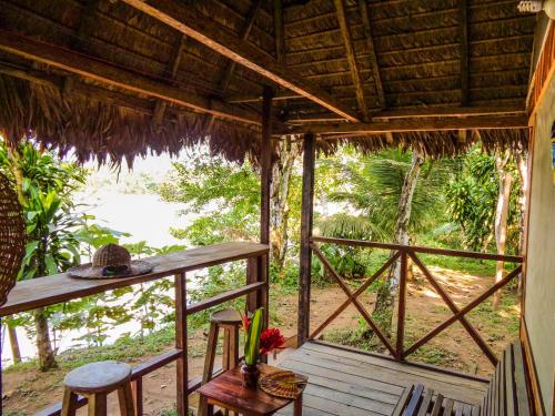 a room with a porch with chairs and a table at Tambopata River in Puerto Maldonado