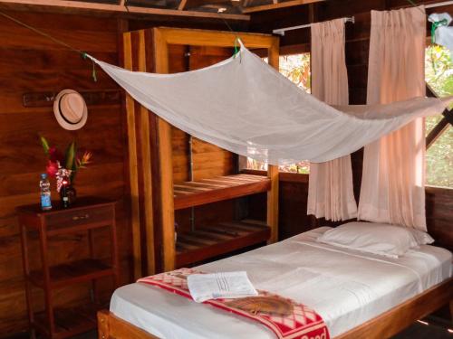 a bedroom with a bed with a mosquito net at Tambopata River in Puerto Maldonado