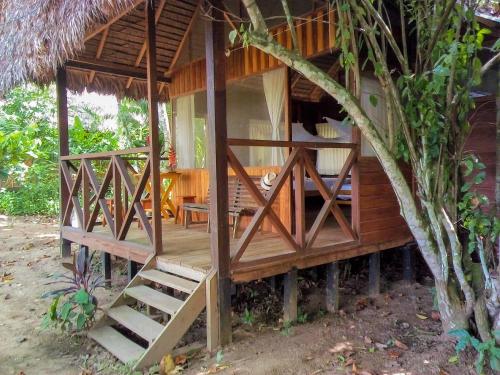 a wooden house with a staircase in front of it at Tambopata River in Puerto Maldonado