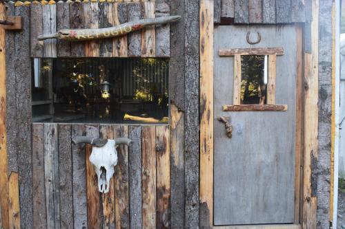 an old wooden door with a cow skull on it at Camping Rio de las Vueltas in El Chalten