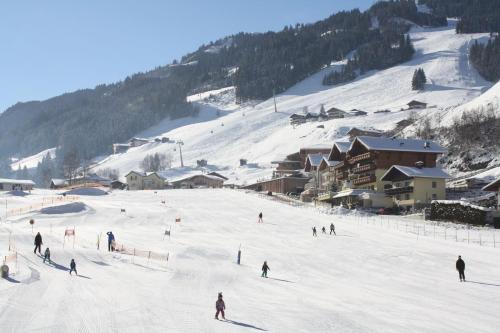 a group of people skiing down a snow covered slope at Hotel Kristall in Grossarl