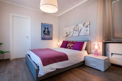 a bedroom with a bed and a night stand with a lamp at Apartments La Lombarda Centro Storico Stresa in Stresa