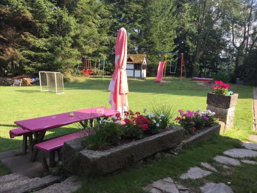 a picnic table with an umbrella next to a playground at Chalet in Ore Mountains near Ski Slopes in Jindřichovice