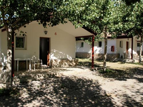 a courtyard of a house with a table and trees at Rustic Mountain Retreat in La Puebla de Roda