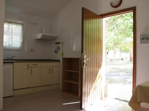 a kitchen with a door open to a kitchen with a sink at Rustic Mountain Retreat in La Puebla de Roda