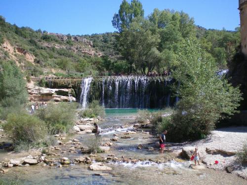 a group of people standing in a river with a waterfall at Rustic Mountain Retreat in La Puebla de Roda