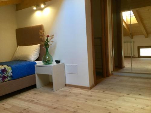 a bedroom with a bed and a vase with flowers on a table at Villa delle Querce in Tremosine Sul Garda