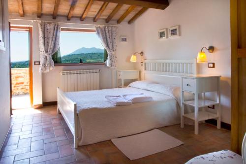 a bedroom with a bed and a desk and a window at Poggio Cantarello Vacanze in Chiusi