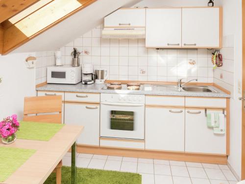 黑森林貝爾瑙的住宿－伊西多爾公寓，厨房配有白色家电和桌子