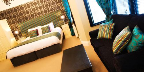 a bedroom with a bed and a couch at The Grafton in Harrogate