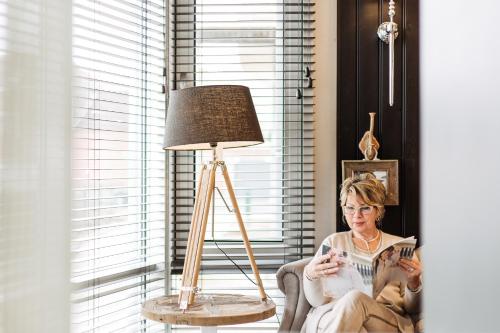 a woman sitting in a chair next to a lamp at West Bay in Middelkerke