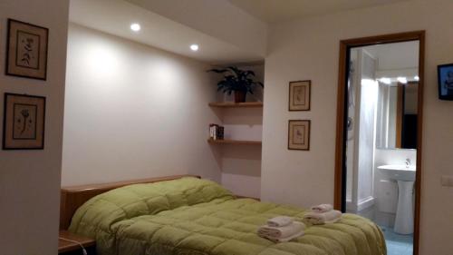 ein Schlafzimmer mit einem grünen Bett und Handtüchern darauf in der Unterkunft Il Pozzo in Sorrent