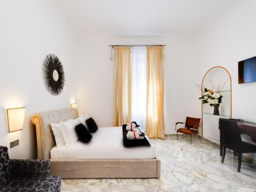 a bedroom with a bed and a couch and a chair at Queen Palace Suites in Rome