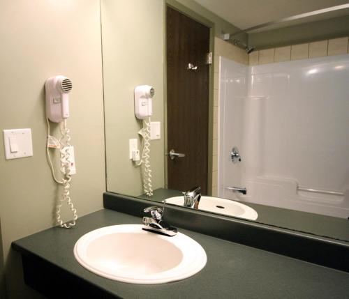 a bathroom with a sink and a mirror and a phone at Super 8 by Wyndham Truro NS in Truro