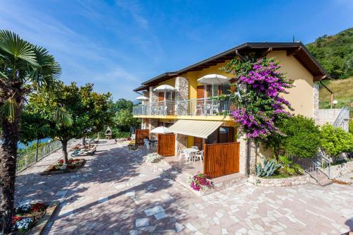 a house with a balcony with purple flowers on it at Taki Village in Brenzone sul Garda