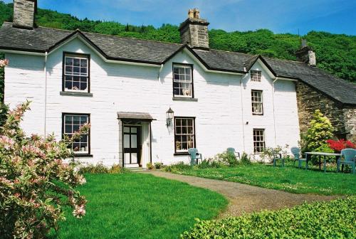 una casa blanca con un camino que conduce a ella en Gogarth hall Farm holidays, en Pennal