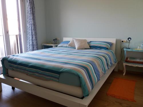 a bedroom with a bed with a striped blanket at Il Giardino in Colico