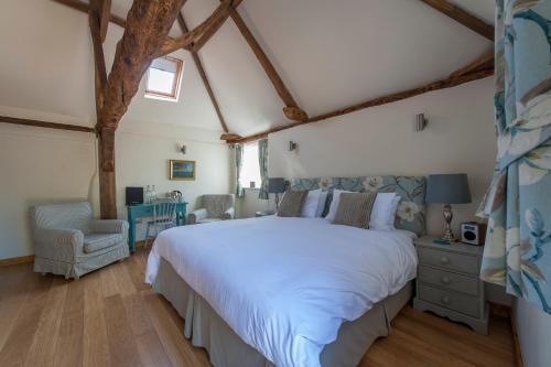 a bedroom with a large white bed and a chair at Hubbard's Luxury Bed and Breakfast in South Creake