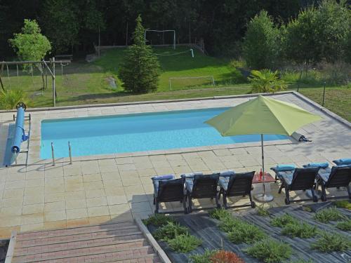 a green umbrella and chairs next to a swimming pool at Spacious villa in Piquecos with private pool in Piquecos
