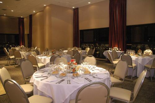 a banquet room with white tables and chairs with glasses at Howard Johnson Plaza Jujuy in San Salvador de Jujuy