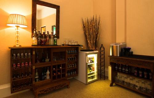 a room with a small refrigerator and a mirror at The Collingdale Guest House in Ilfracombe