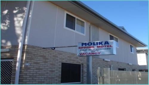 a building with a sign on the side of it at Molika Springs Motel in Moree