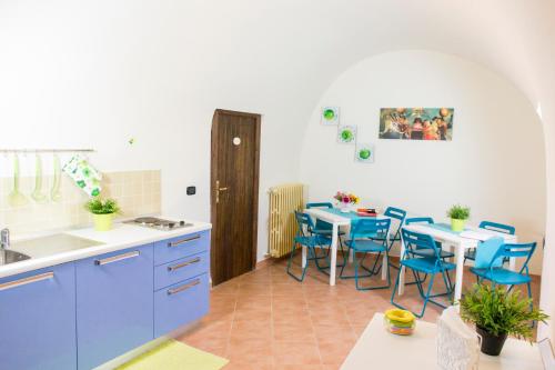 una cocina con armarios azules, mesas y sillas azules en Le Stanze Dell'Imperatore B&B, en Melfi