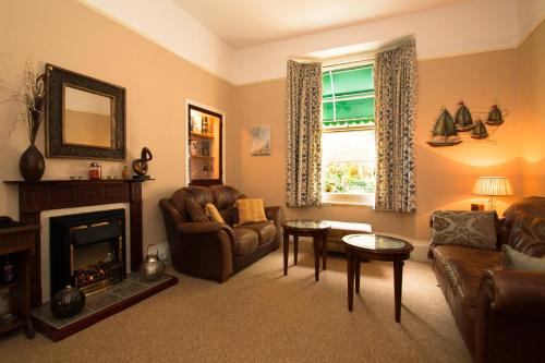 a living room with a couch and a fireplace at The Collingdale Guest House in Ilfracombe