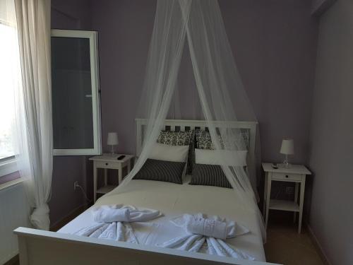 a bedroom with a white bed with a canopy at Villa Anna Maria in Kriopigi