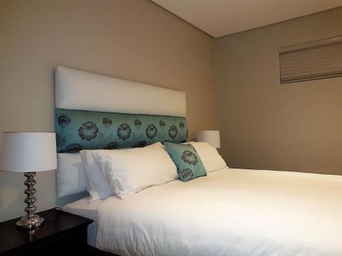 a bedroom with two beds and two lamps at Zimbali Suites 106 in Ballito