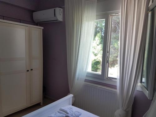 a bedroom with a bed and a window at Villa Anna Maria in Kriopigi