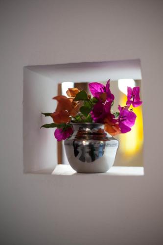 a vase filled with flowers sitting on a shelf at East Surf Cabana in Arugam Bay