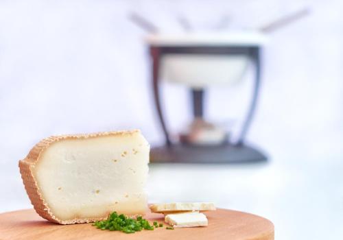 a piece of cheese on a wooden cutting board at Agroturistika kozí farma Rožnov pod Radhoštěm in Rožnov pod Radhoštěm
