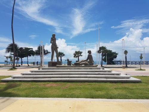 a statue of a man and a woman sitting on the grass at Iracema Residence Hotel Flat in Fortaleza