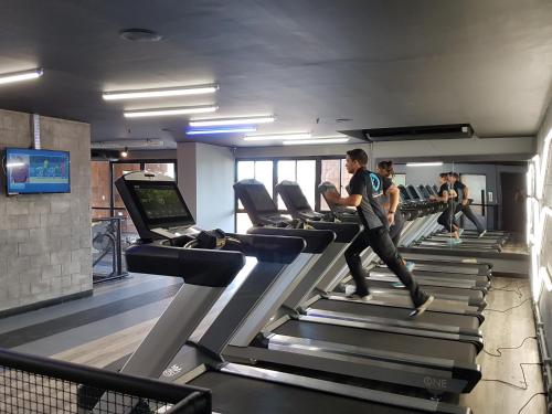 a man running on a treadmill in a gym at Iracema Residence Hotel Flat in Fortaleza