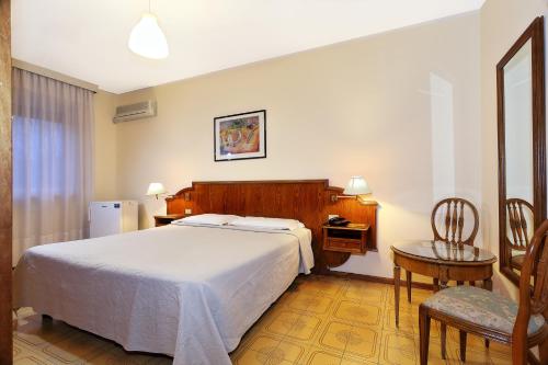 a bedroom with a bed and a desk and a chair at Hotel Residence Sogno in Novara