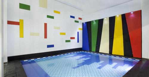 a swimming pool in a room with colorful tiles at Amaris Hotel Cihampelas in Bandung