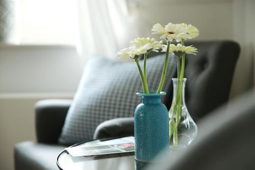 a blue vase with white flowers on a table at PicaBella - B&B en atelier in Laren