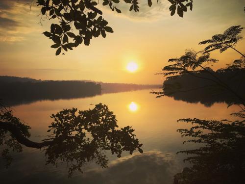 a view of a lake with the sun setting at Las Lagunas Boutique Hotel in Flores