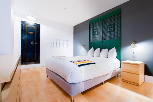 a bedroom with a large white bed with a green headboard at Les Lofts St-Joseph - Par Les Lofts Vieux-Québec in Quebec City