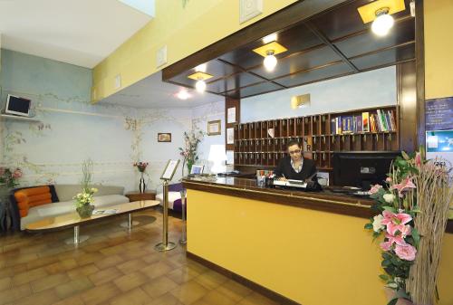 a woman sitting at a counter in a library at Hotel Residence Sogno in Novara