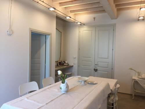 a white table with white chairs and a white vase with flowers at Villa Pacchioni in Cavezzo