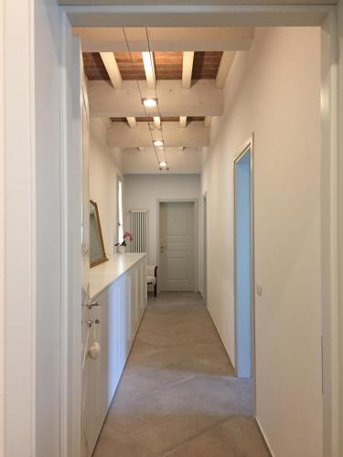 a hallway with white walls and a ceiling with lights at Villa Pacchioni in Cavezzo