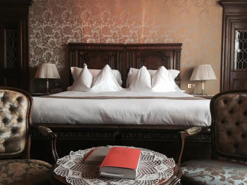 a bedroom with a bed with a red book on a table at Hotel Villa Fiordaliso in Gardone Riviera
