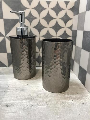two black containers sitting on a counter in a bathroom at PlacesAppart in Arras