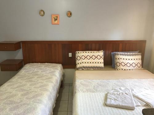 two beds in a hotel room withskirts at Pousada Castelinho in Caldas Novas