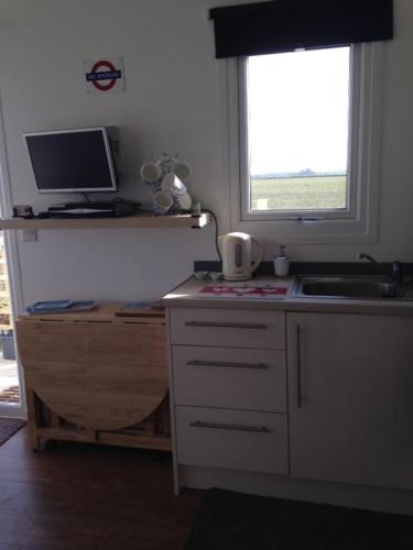 a kitchen with a sink and a computer on a counter at For-Get-Me-Not Chalet semi detached in Bridlington